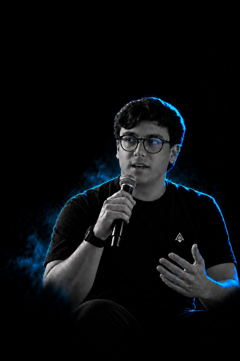 O CEO da AIONS falando ao microfone, em preto e branco com luz azul.